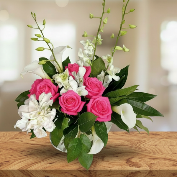 6 roses, 6 callas, lilies, and dendrobium orchids, with assorted greenery, on a glass vase.