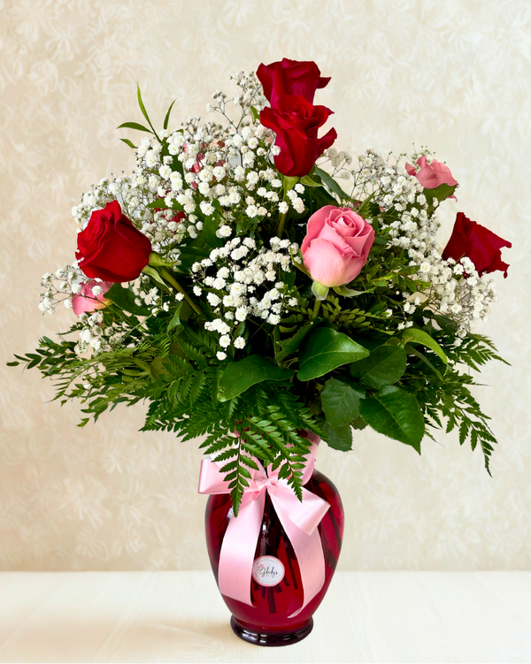 Classic bouquet of 12 roses in assorted colors with greenery in a glass vase