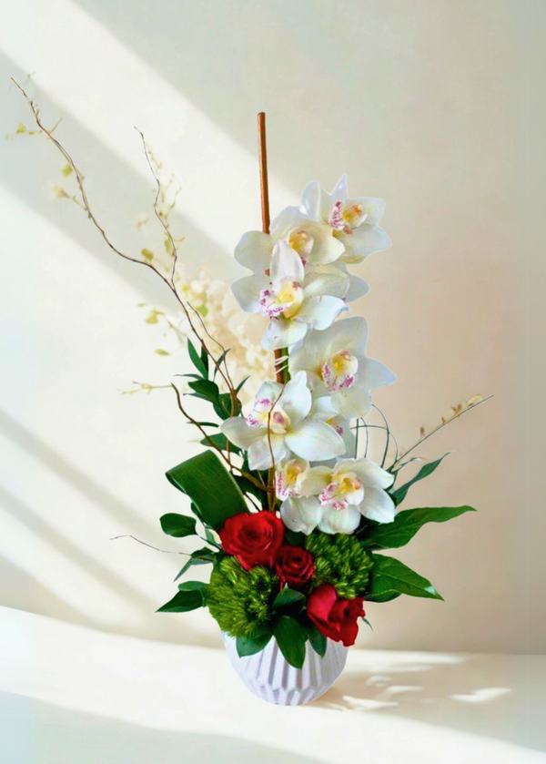 Elegant arrangement with cymbidium orchids, roses and lush greenery.
Perfect for any occasion.
Valentine's