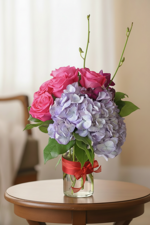 Arrangement with hydrangeas, 6 roses, and dendrobium orchids in a vase