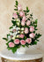 Spiral design featuring a blend of roses, spray roses, and orchids paired with lush greenery.